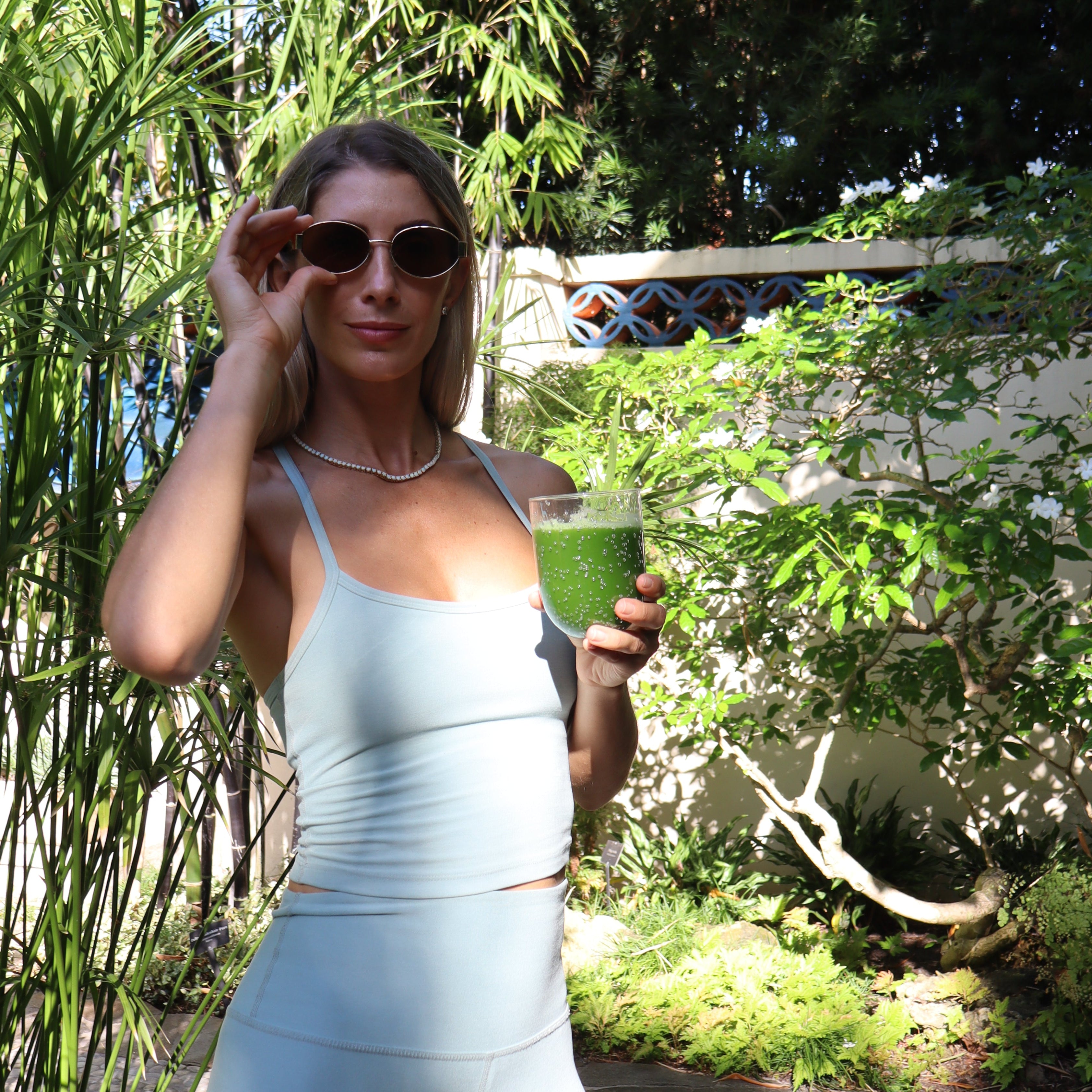 Female model holding a ceremonial matcha in a garden setting