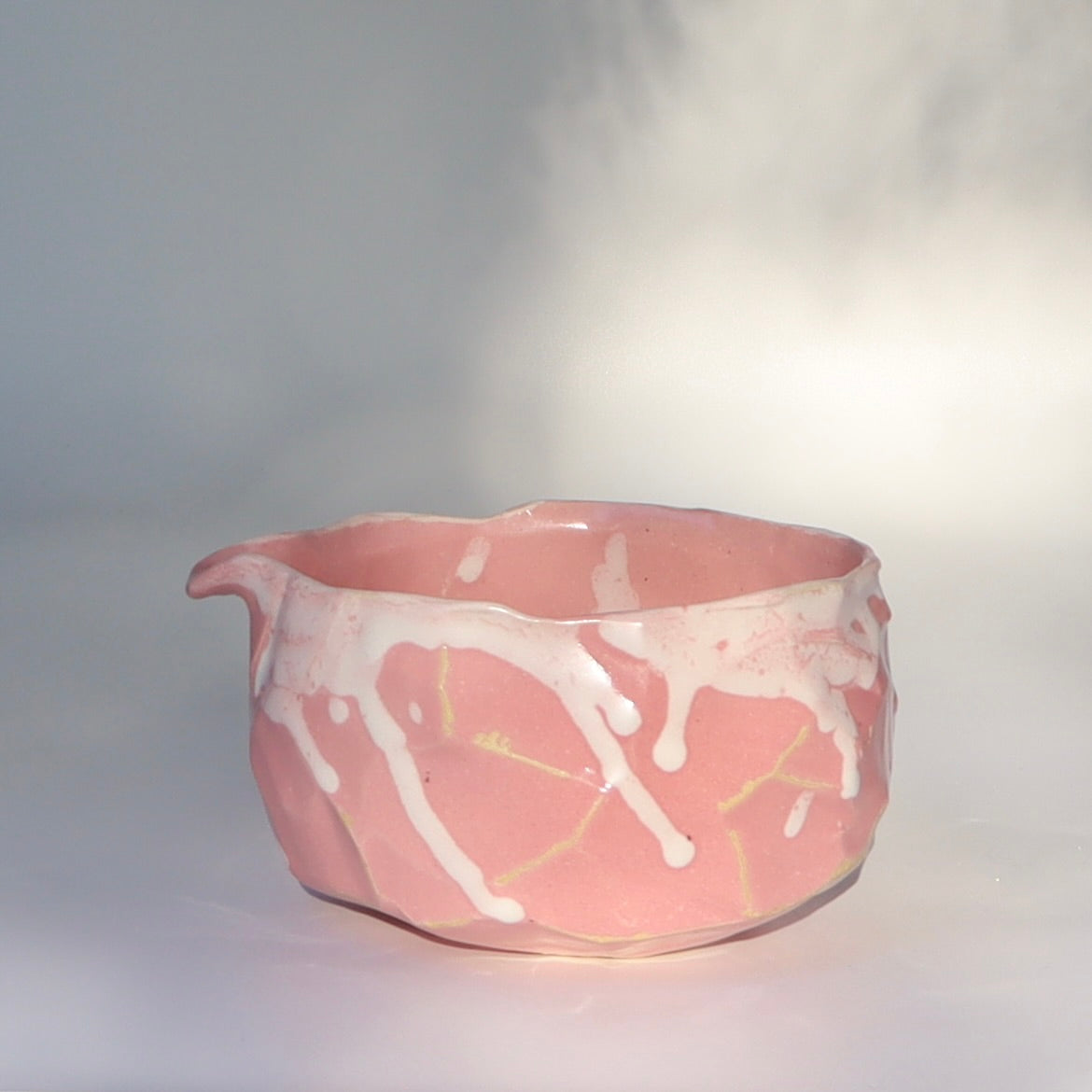 Traditional Japanese kurinuki tea bowl pink glaze full view, spout on left side